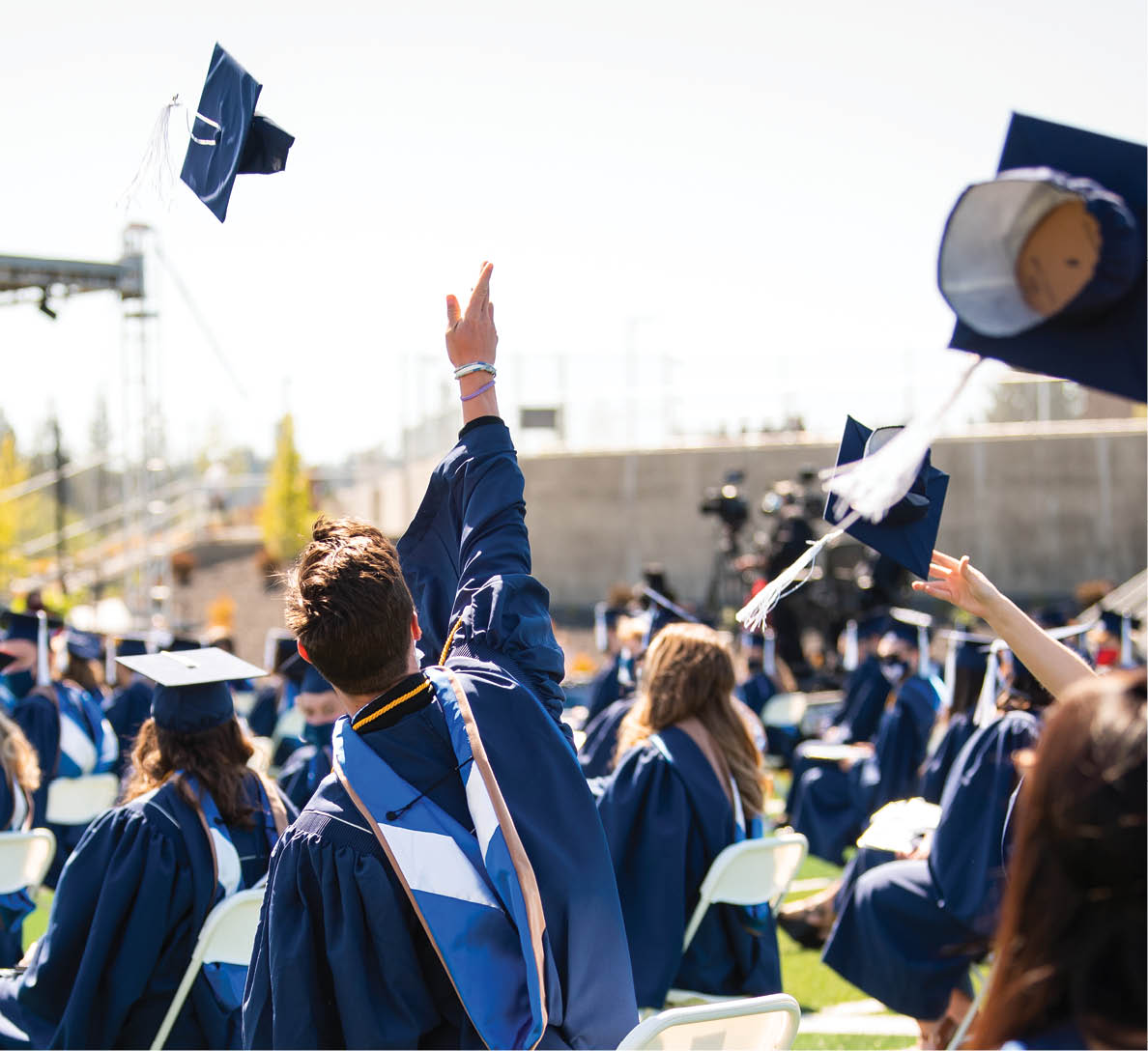 Students tossing mortarboard caps in the air at Spring 2021 Commencement ceremony.