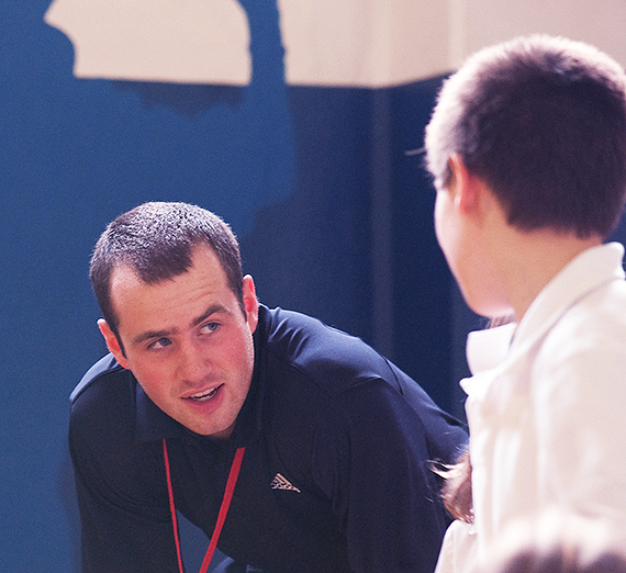 A coach speaks with a student