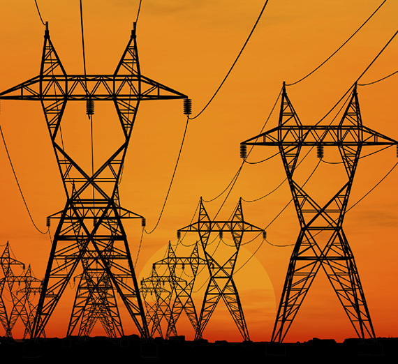 Power lines in front of an orange sky 