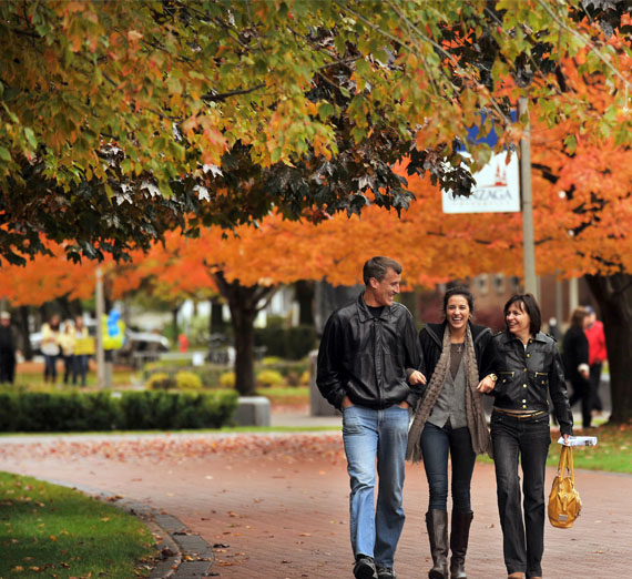 student walks with parents on campus 