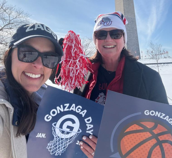 Spirited Gonzaga University employees pose with Gonzaga Day cheer cards in front of the Washington Monument in D.C.
