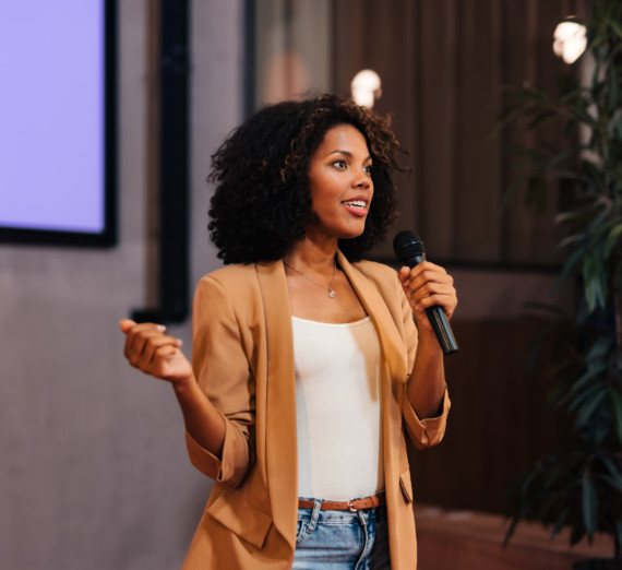 A woman holding a microphone giving a presentation