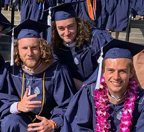 Close up of three graduates smiling.
