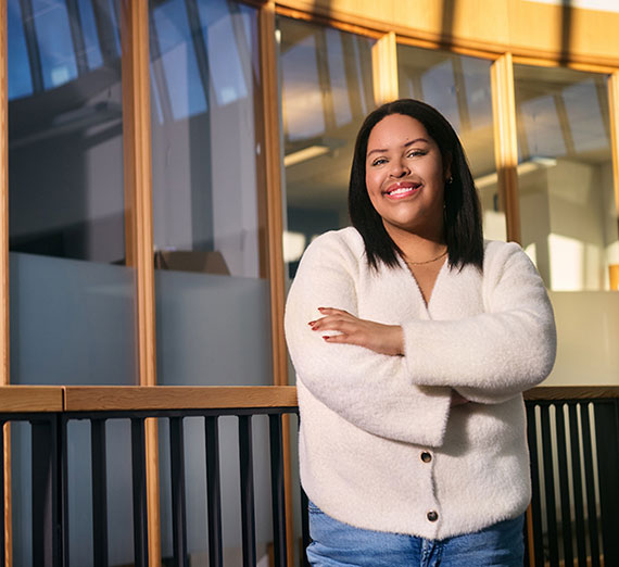 Student near a railing and glass background.