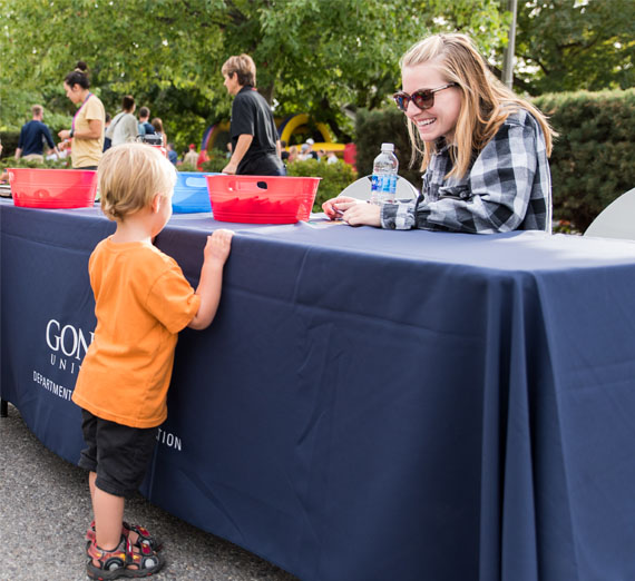 volunteer with child at block party