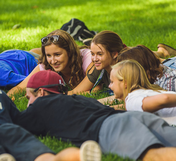 Students laying on grass playing games