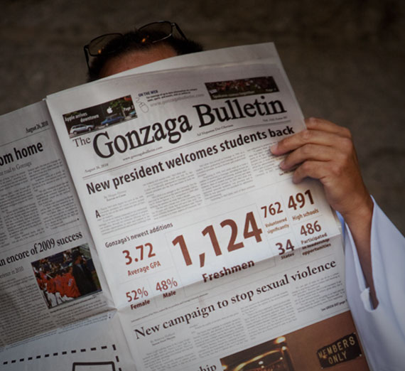 Priest reading the Gonzaga Bulletin student newspaper