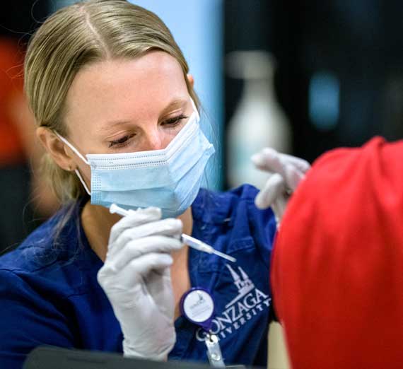 A Gonzaga nursing student administering a COVID-19  vaccine.