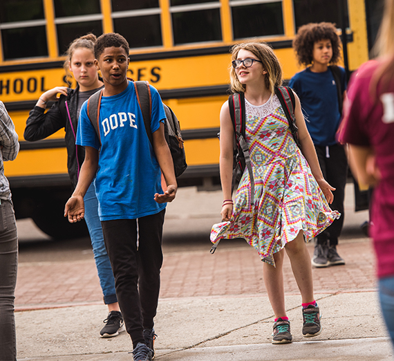 Students walk off a schoolbus.