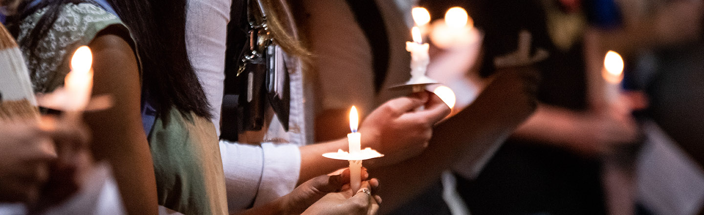 Decorative image of people holding lit candles.
