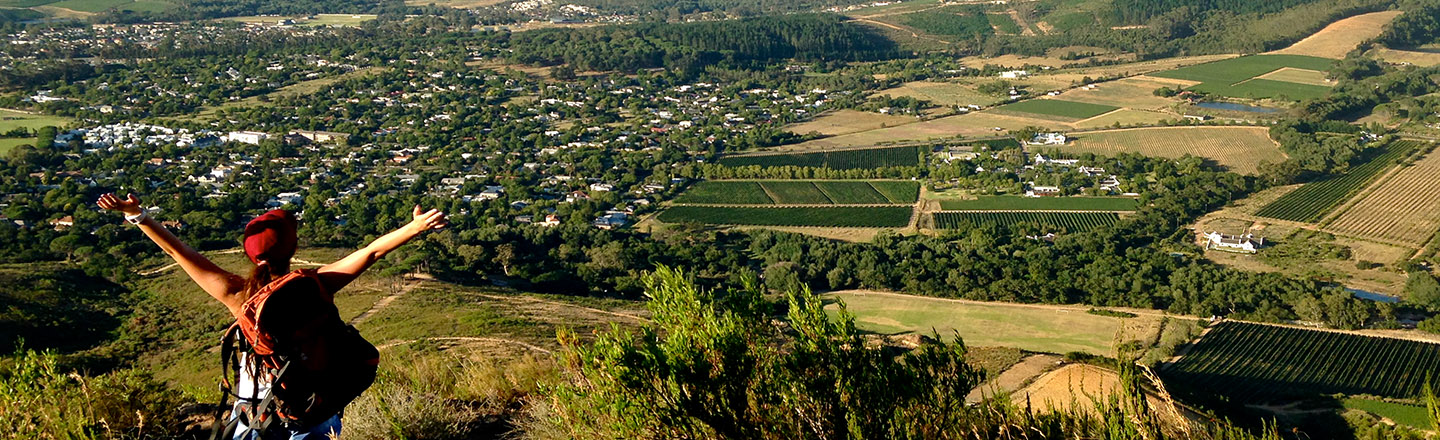 A study abroad student hiking above a green valley