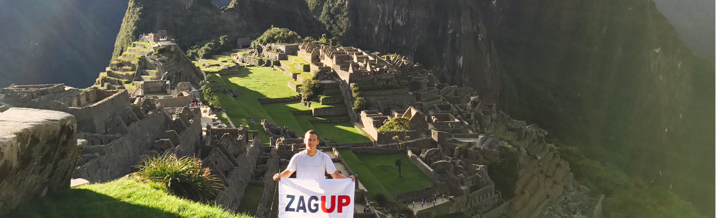 A Gonzaga student holding a ZagUp flag at Machu Picchu. Photo by Mason Matteoni