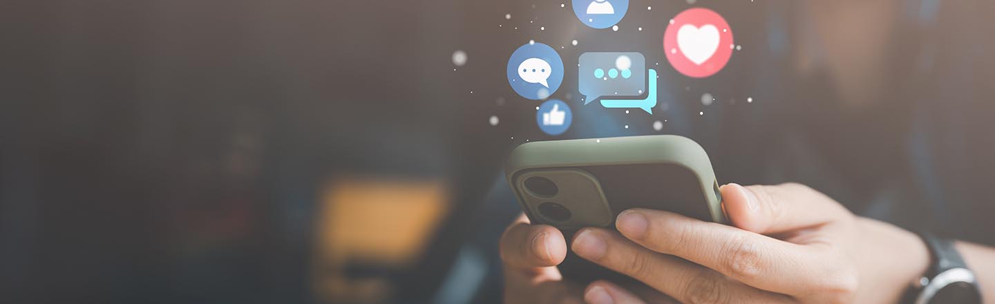 iPhone with digital social media bubbles coming out of the screen