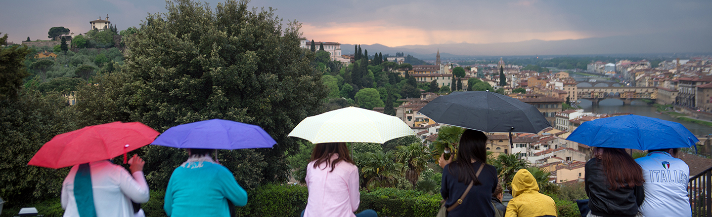 Gonzaga University Italian Studies students with umbrellas looking over an Italian city