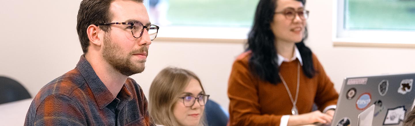 Graduate Accounting Students at Desks Listening to Professor