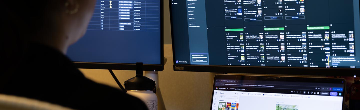 women works at desk with social media scheduler on screen