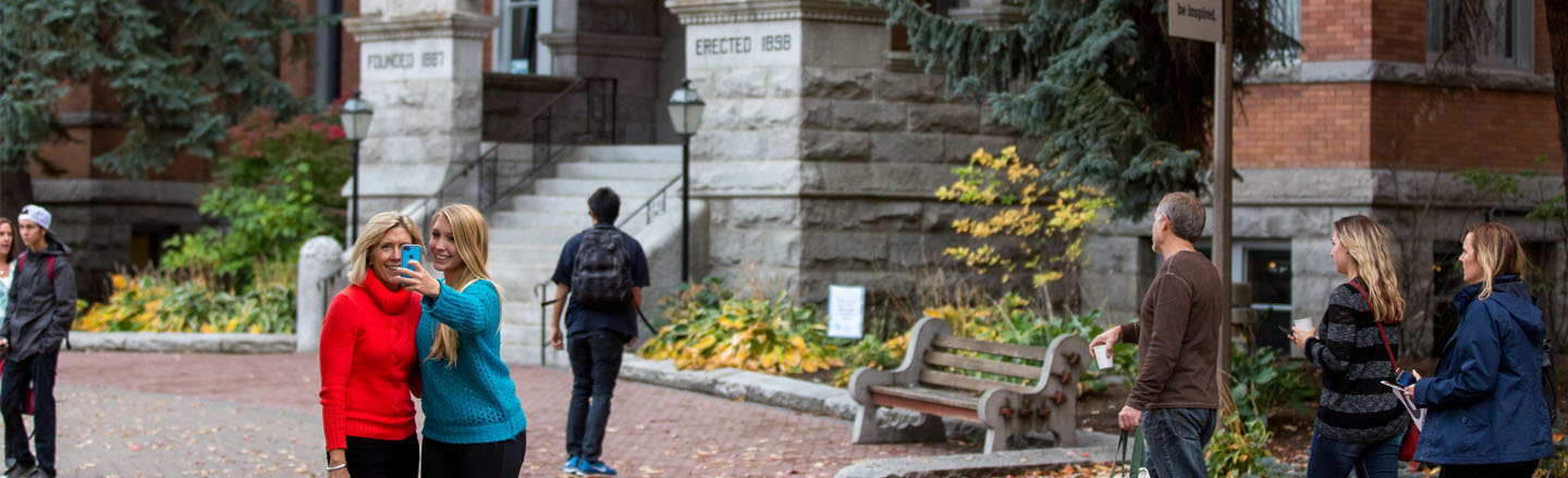 51�Թ� and parent take picture in front of College Hall 
