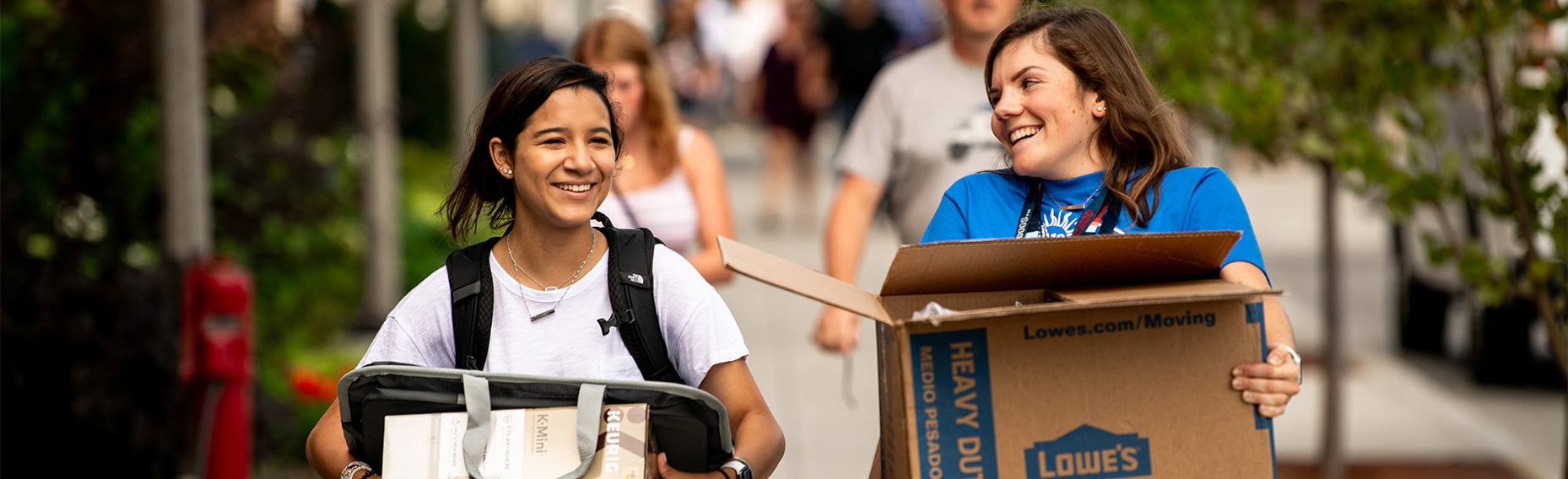 two students carrying boxes