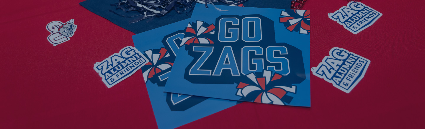 close-up of a GO ZAGS sign and Zag Alumni & Friends stickers