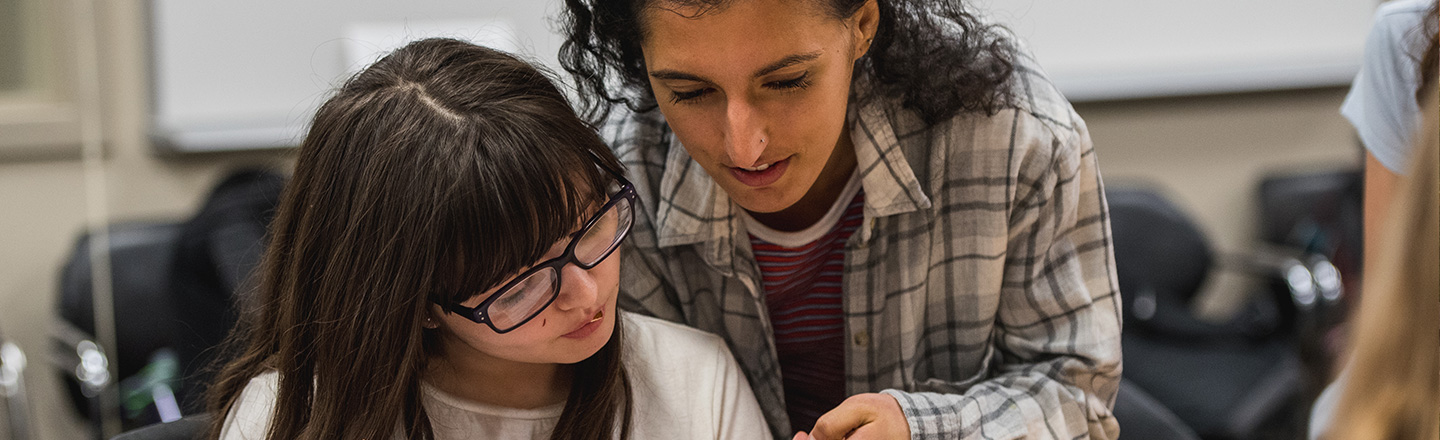 A teacher reads with a student.