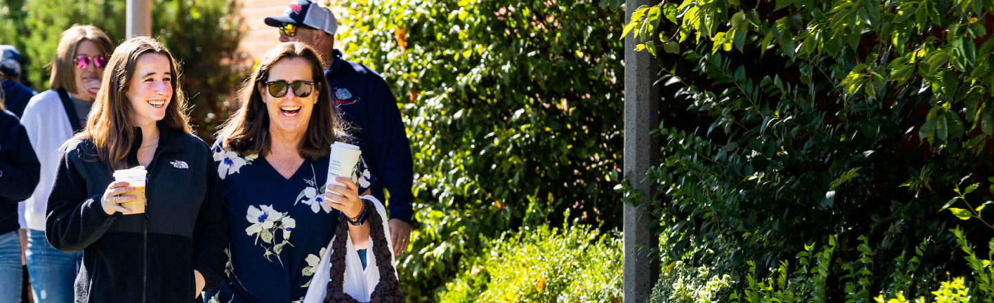 Students and their families walking along an outdoor path on campus.