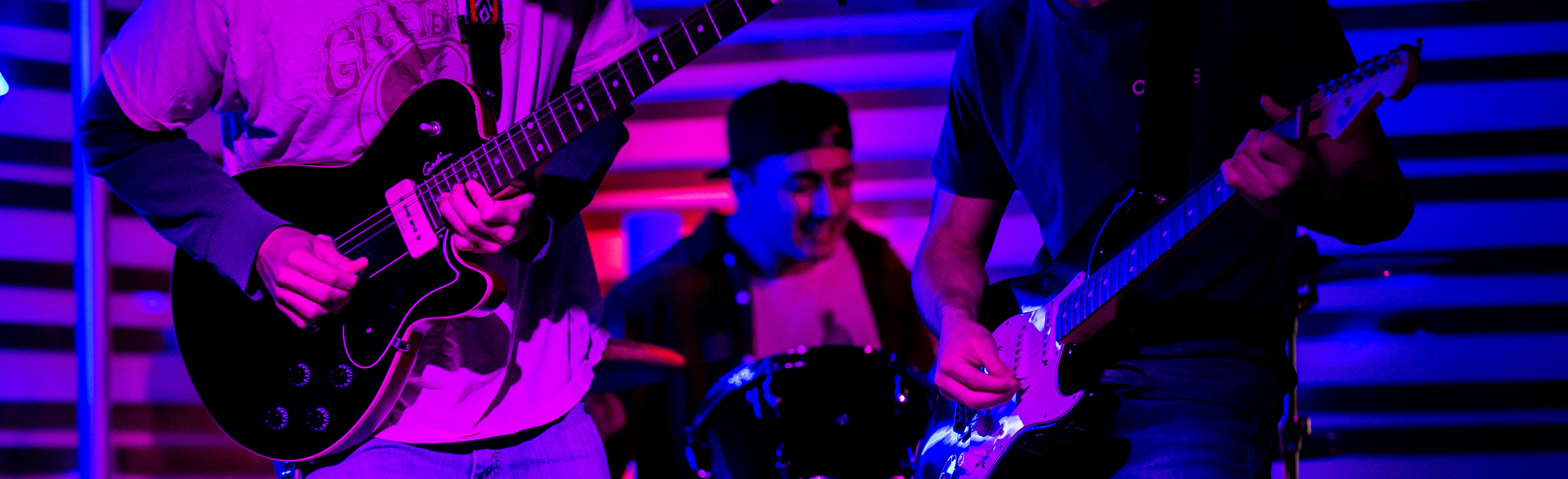 A student band with two guitarists and a drum player
