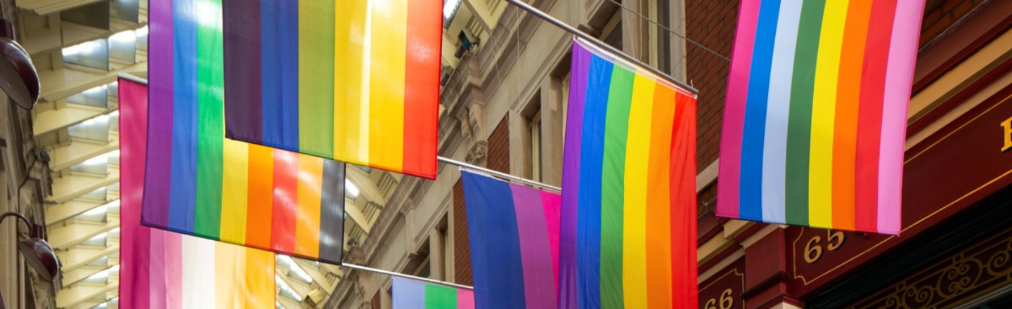 A series of hanging rainbow flags outside