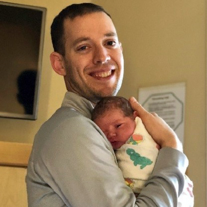 Nick Questad holds his third daughter, Madeline. 