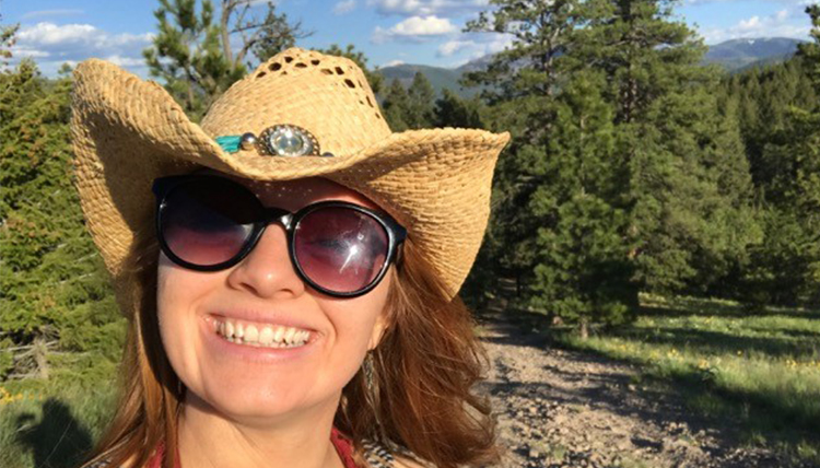 Liv Schneider in Montana countryside with cowgirl hat