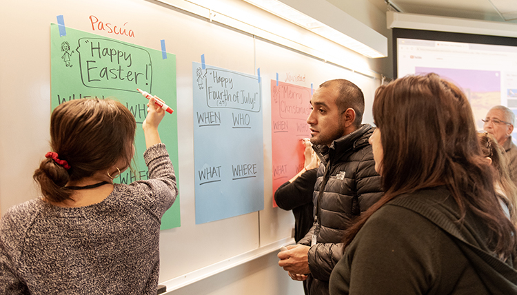 teacher and students review holiday words on a board