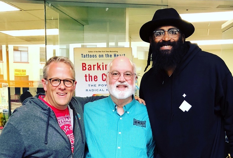 Josh Armstrong, Father Greg Boyle, and Ronny Turiaf smile for a photo.