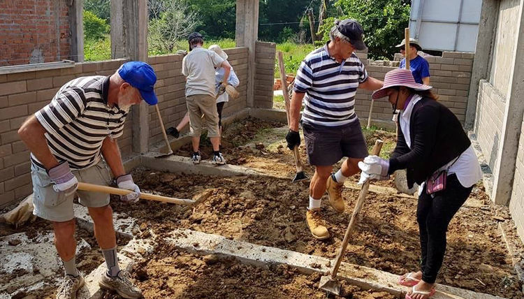 Habitat for Humanity volunteers moving dirt