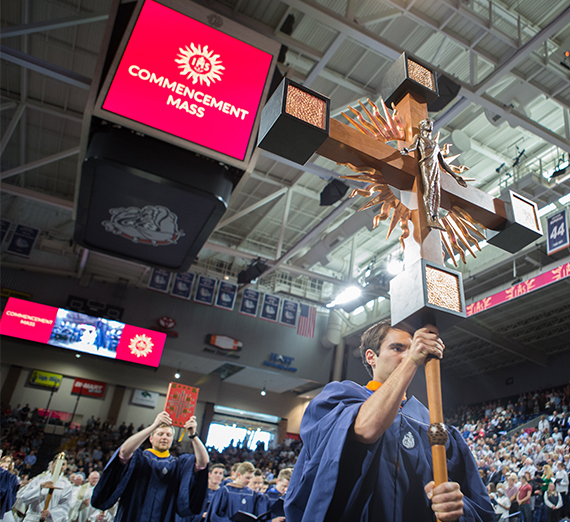 student walks with large cross in Mass processional 