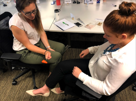 Claire Henson testing her fellow intern Erin Hayes' reflexes.