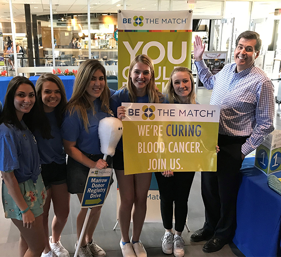 Student volunteers pose with Dr. McCulloh at a Be the Match awareness event. 