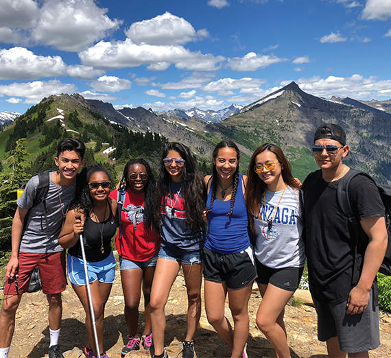 The Act Six scholars pose on top of a hike in the mountains. 