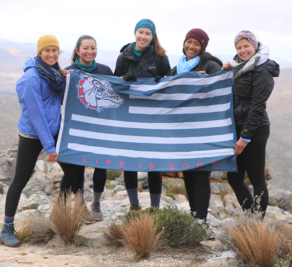 The five Gonzaga student studying abroad in Stellenbosch pose with a Gonzaga flag. 