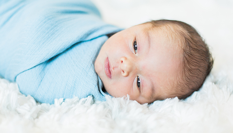 baby boy wrapped in blue blanket