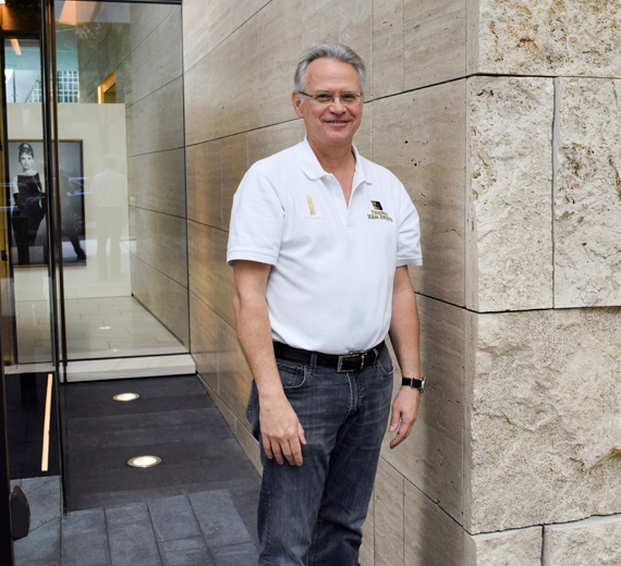 Kevin Daniels smiles outside the entrance to a skyscraper.