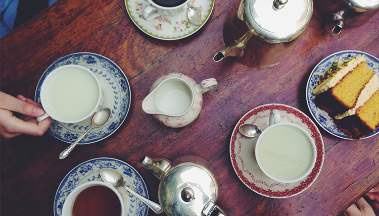 A wooden table filled with tea cups