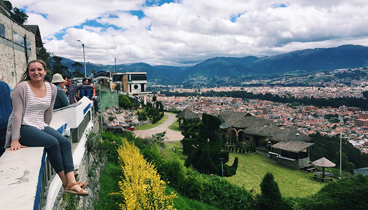 Gonzaga student sits on ledge overlooking city in Ecuador