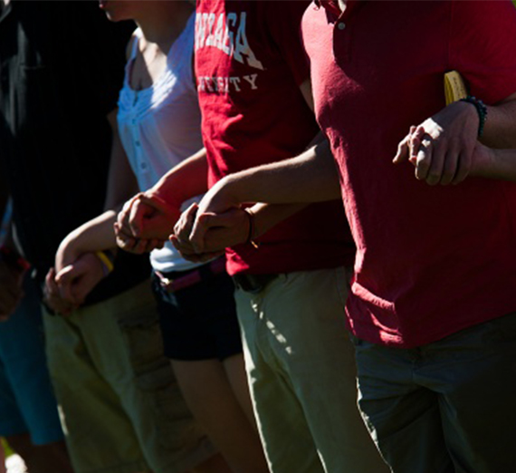 A line of students hold hands in solidarity. 