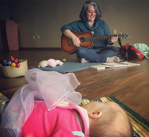 woman plays guitar for therapy for baby