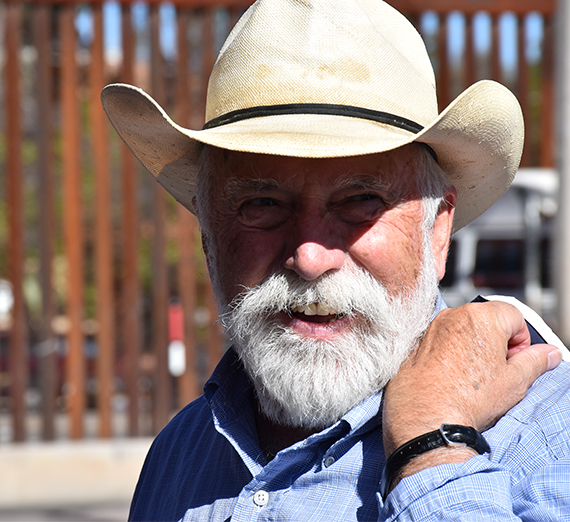 Father Pete Neeley stands near the wall at the Nogales border between the U.S. and Mexico