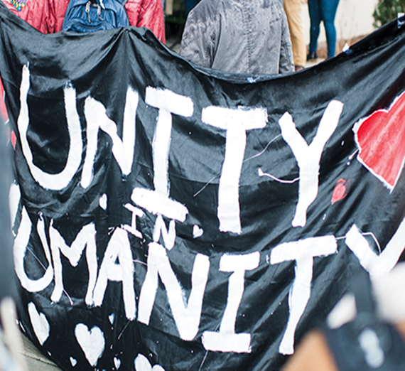 Students holding sign that reads "unity in humanity"