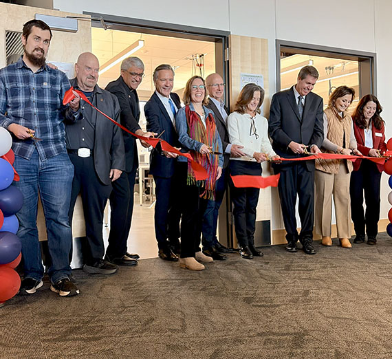 10 people cutting a red ribbon