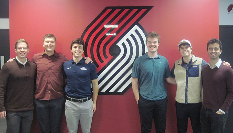Six members of the Gonzaga Sports Consulting Group pose with the Portland Trailblazers logo