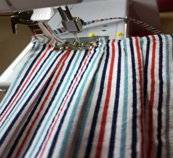 Close shot of masks under thread and needle, on sewing machine.