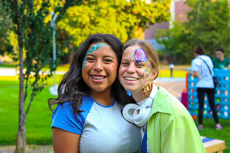 Two people with face paint smiling.