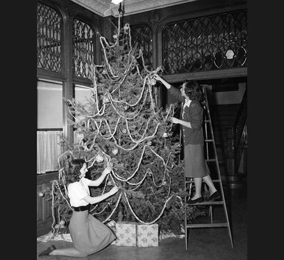 Two girls decorating a Christmas tree in college hall, 1948